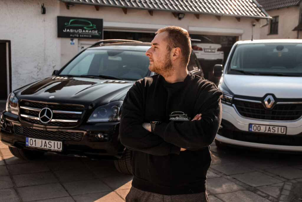 Mechanik Jasiu Garage przed warsztatem w Chróścicach, obok Mercedes i Renault Trafic