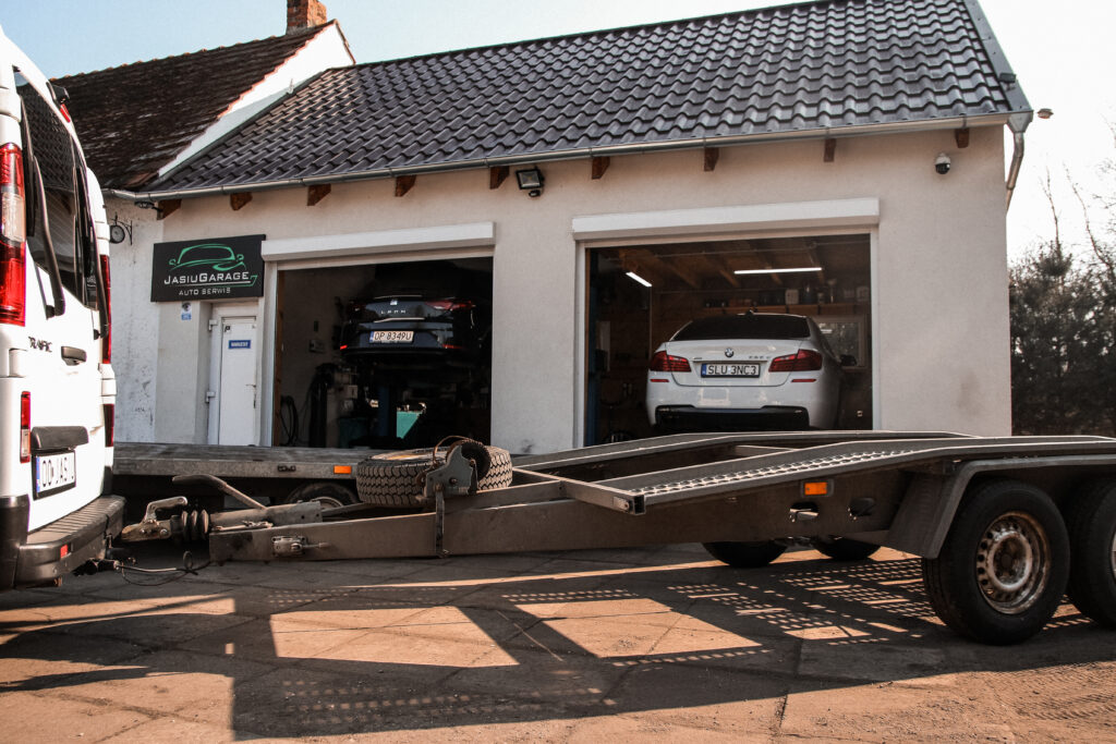Laweta do transportu aut przed warsztatem Jasiu Garage w Chróścicach