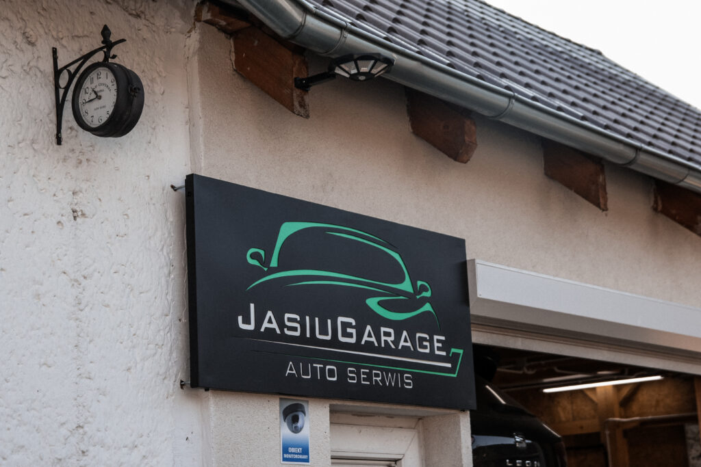 Szyld warsztatu Jasiu Garage Auto Serwis na budynku w Chróścicach